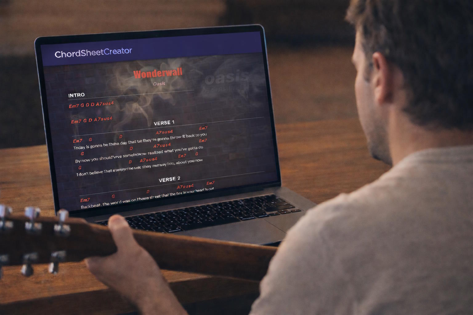 Guitarist using ChordSheetMaker on a laptop